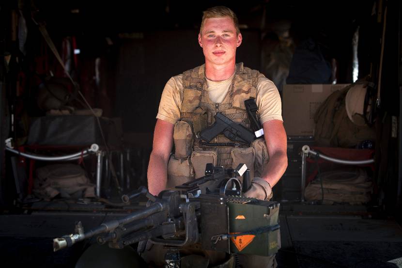 Een boordschutter achter een MAG-machinegeweer op de achterklep van een Chinook-transporthelikopter.
