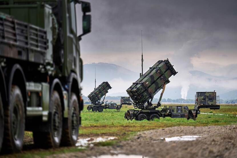 2 Patriots-luchtverdedigingssystemen. Op de voorgrond een vrachtwagen waarop een Patriot wordt vervoerd.