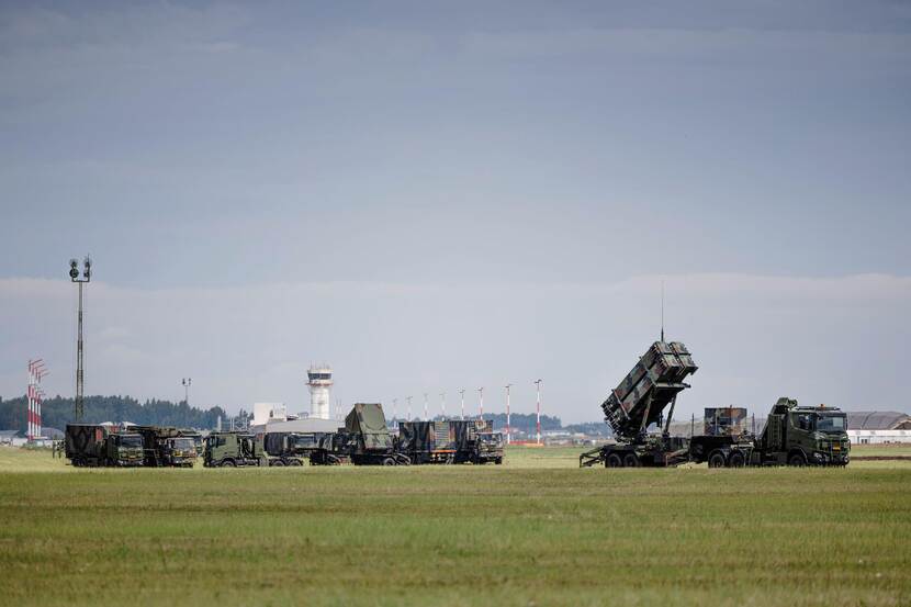 Overzichtsfoto met meerdere Patriot-luchtverdedigingssystemen en vrachtwagens waarop ze zijn vervoerd.