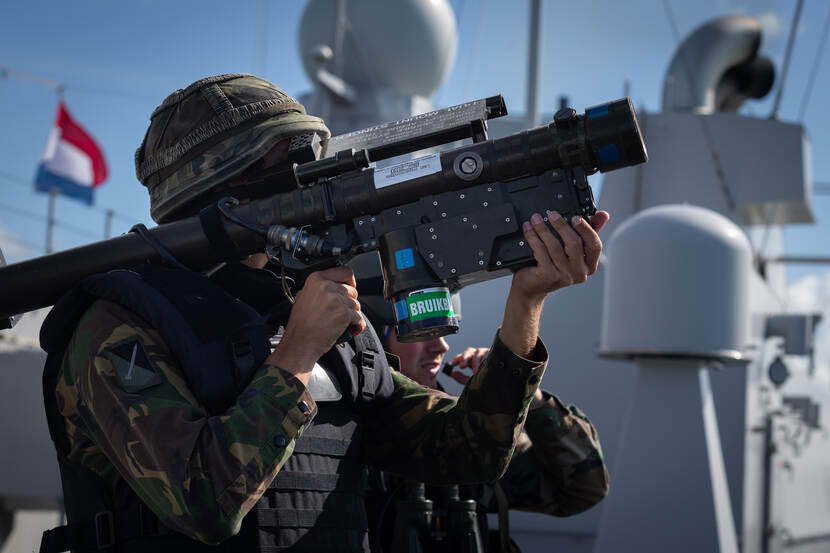 Militair staat op een schip met op zijn rechter schouder een Stinger Manpad.