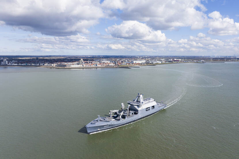 Zr.Ms. vaart weg van een stad.