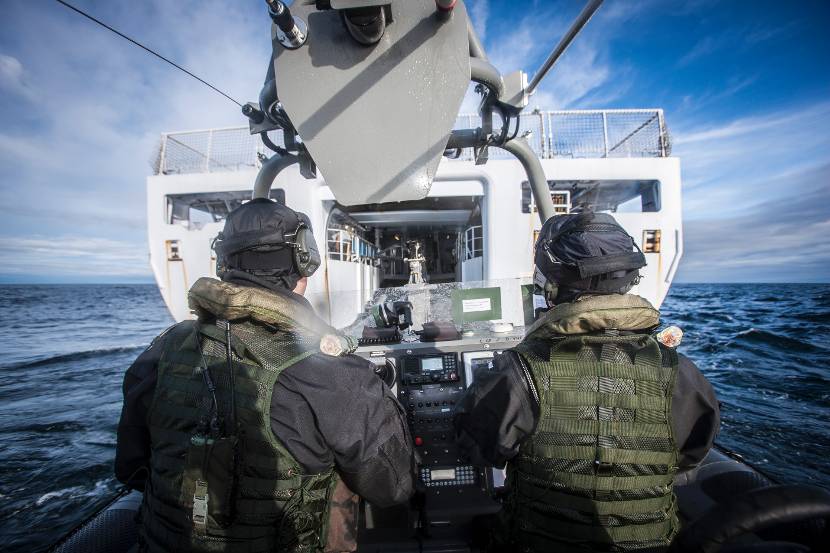 Een Frisc met 2 bemanningsleden vaart het interne dok in van een schip.