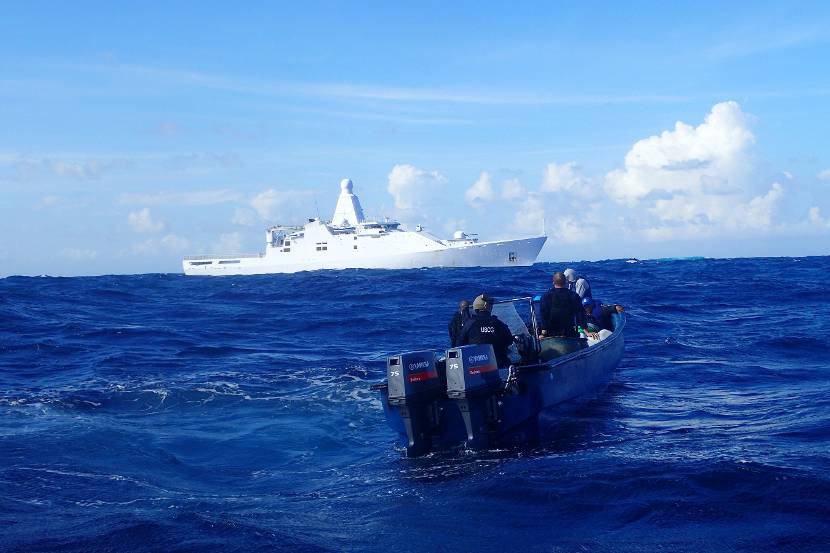 Patrouilleschip Zr.Ms. Friesland met op de voorgrond een drugssmokkelboot.