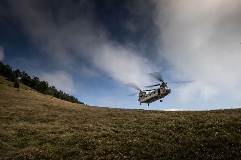 Chinook landt op een heuvel.