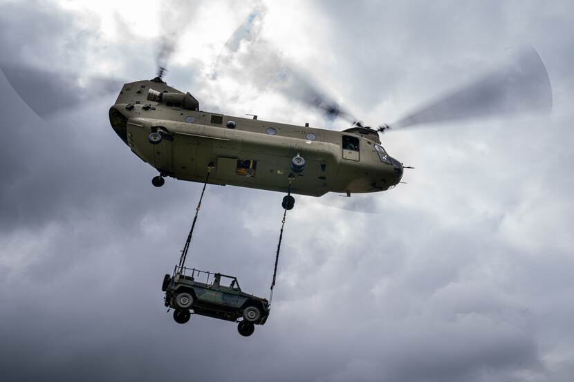 Een Chinook-transporthelikopter vervoert een jeep.