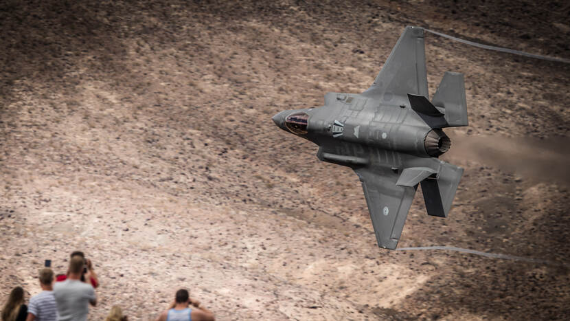 Bovenaanzicht F-35 tijdens vlucht vanaf Edwards Air Force Base om boordkanon te testen (oktober 2018). Toeschouwers op voorgrond zichtbaar.
