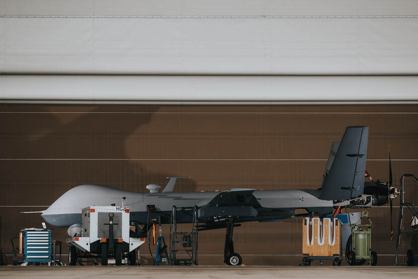 Een MQ-9 Reaper in een openstaande hangaar van de linker zijkant bezien.