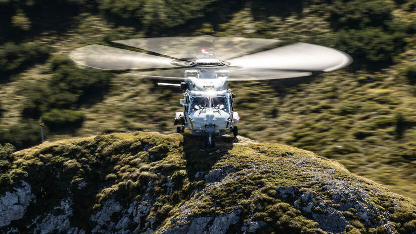 Helikopter op een bergtop met roterende bladen.