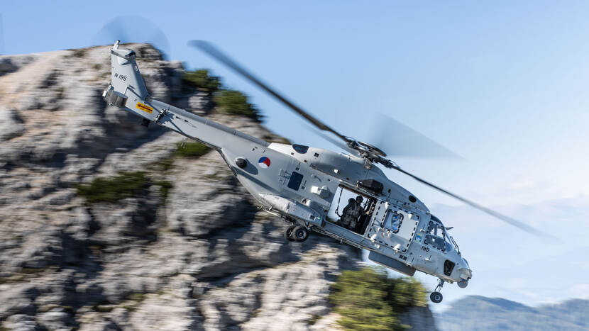 Helikopter met op de achtergrond bergen.