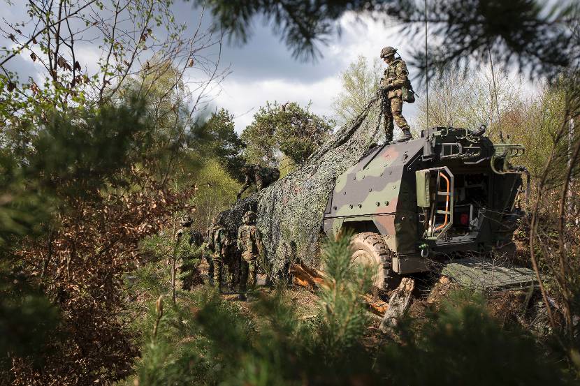 Militairen camoufleren een Boxer-ambulance.