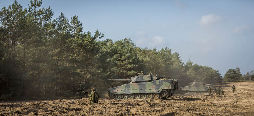 2 CV90's en zogenoemde uitgestegen infanteristen staan langs de bosrand tijdens een oefening op de Leusderheide (september 2018).
