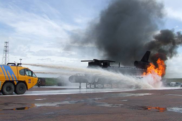 Crashtender blust met dakkanon een brand in een helikopter op een oefenterrein.