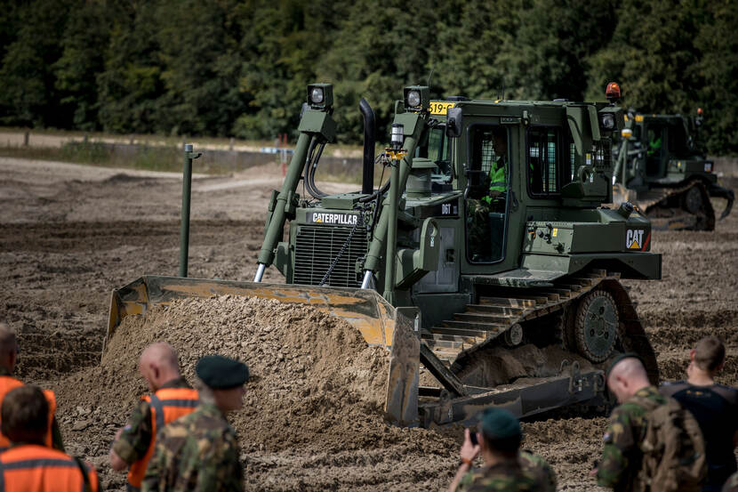 Caterpillar rupsdozer schuift zand voor zich uit.