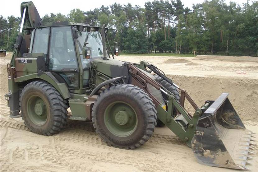 Graaflaadcombinatie 4CX-M staat met graafarm in het zand.