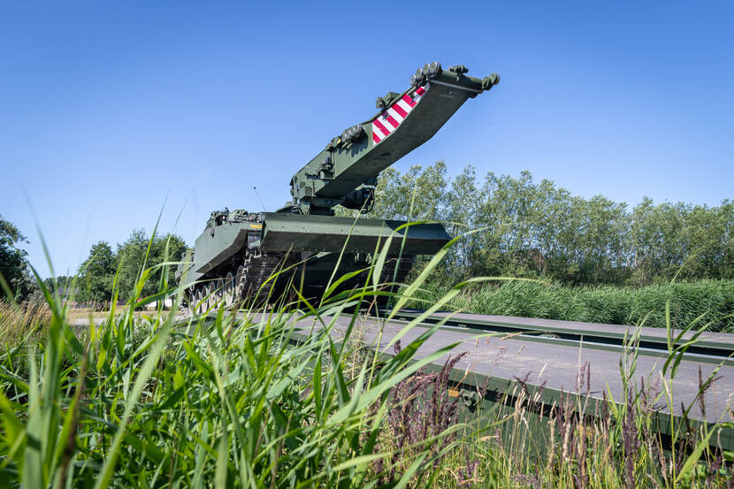 Brugleggende tank rijdt over brug.