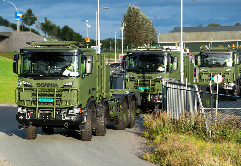 Nieuwe 8-wielaangedreven (4-assig) Scania's Gryphus in de high operational-uitvoering arriveren in een rij bij een kazerne.