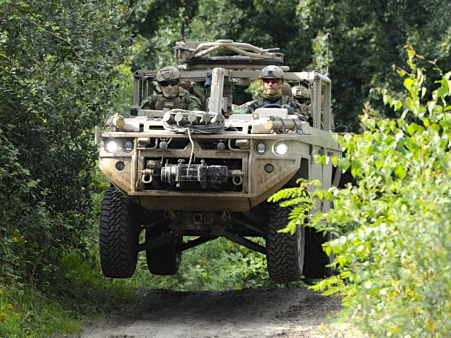 Een Vector rijdt hard over een hobbel en komt met 4 wielen los van de grond.