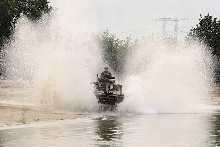 Water spat meters hoog op als een Vector door het water van een vijver rijdt.