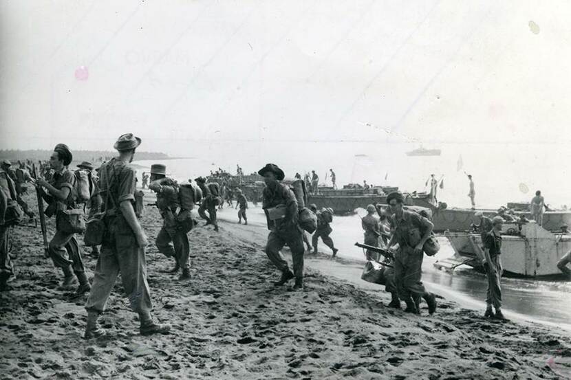 1944: militairen lopen het strand op vanuit landingsvaartuigen.