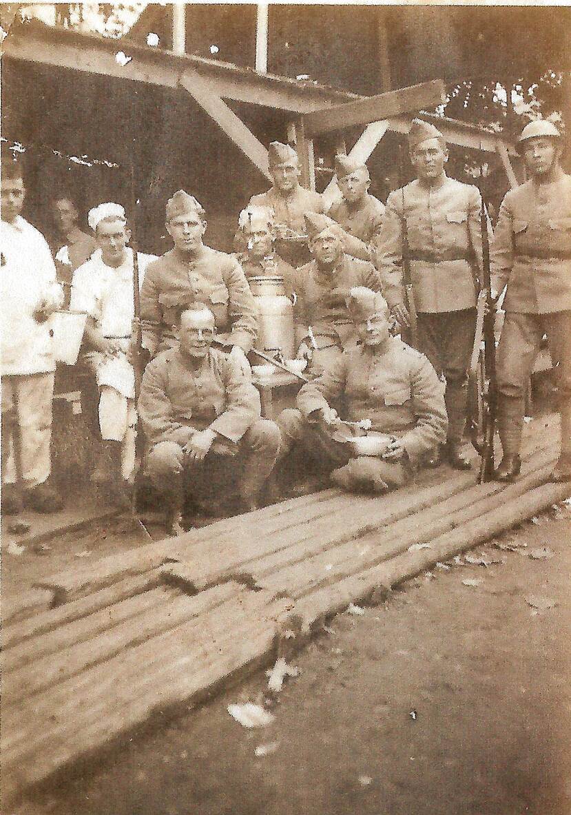 Historische groepsfoto militairen tijdens etenstijd.