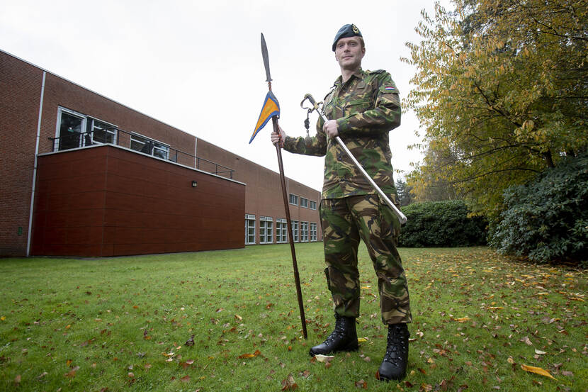 Militair met oude speer en officierssabel.