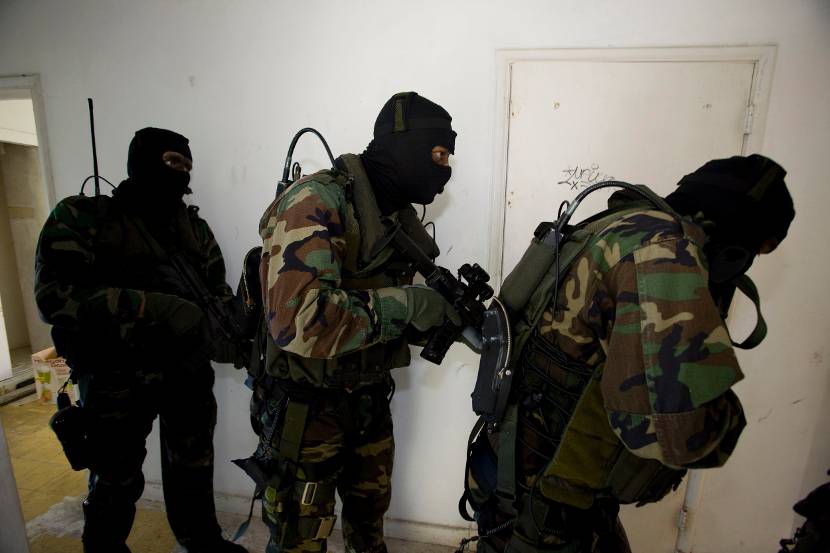 Speciale teams doorzoeken gebouw op terroristen.