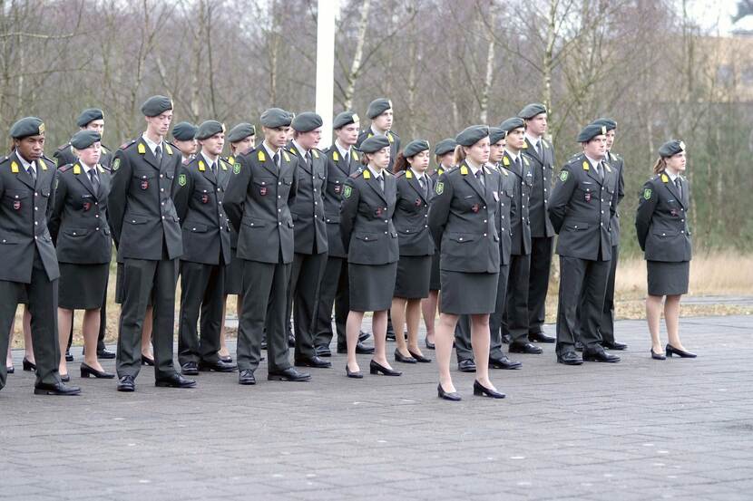 Groep militairen in houding bij beëdiging.