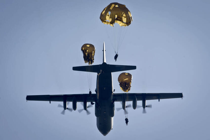 Gezien vanaf de grond: paratroepen van 11 Luchtmobiele Brigade springen uit een Hercules C-130 transportvliegtuig.