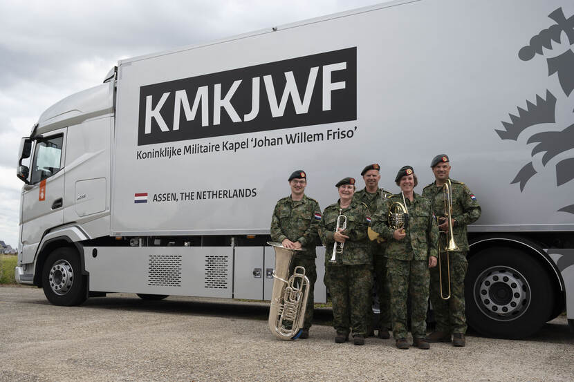 De 5 leden van het Koperkwintet staan voor een vrachtwagen met de tekst: KMKJWF Koninklijke Militaire Kapel 'Johan Willem Friso' Assen, The Netherlands.