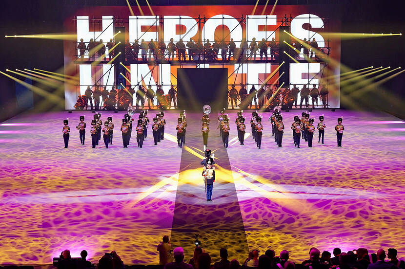 De KMKJWF tijdens de Nationale Taptoe. Op de achtergrond het woord: "heroes".
