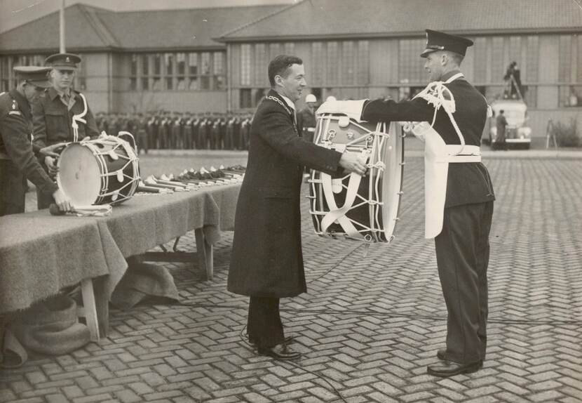 Burgemeester van Apeldoorn Des Tombe overhandigt een van de instrumenten.