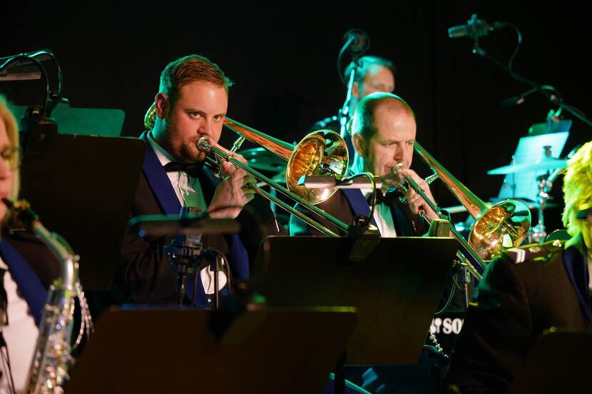 Muzikanten van het orkest Koninklijke Marechaussee spelen trompet.