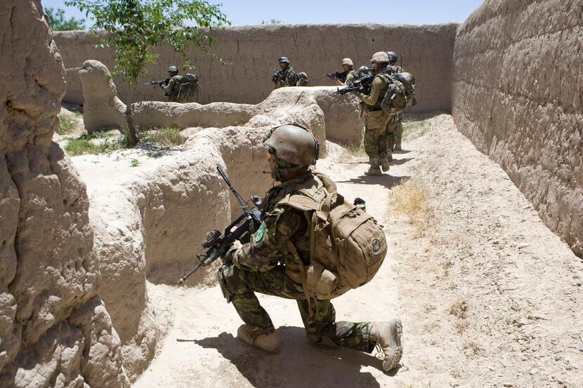 Militairen houden halt tijdens een voetpatrouille in Afghaans dorp.