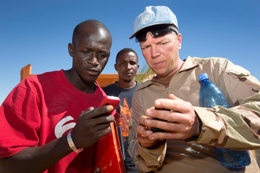 Een Nederlandse militair overlegt met een Malinese ondernemer.
