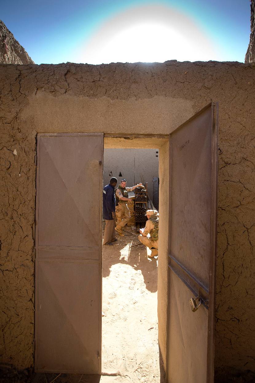 Doorkijkje naar militairen door open deur.