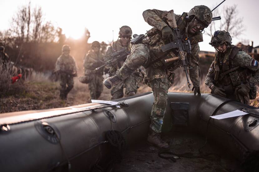 Militair springt in een boot.