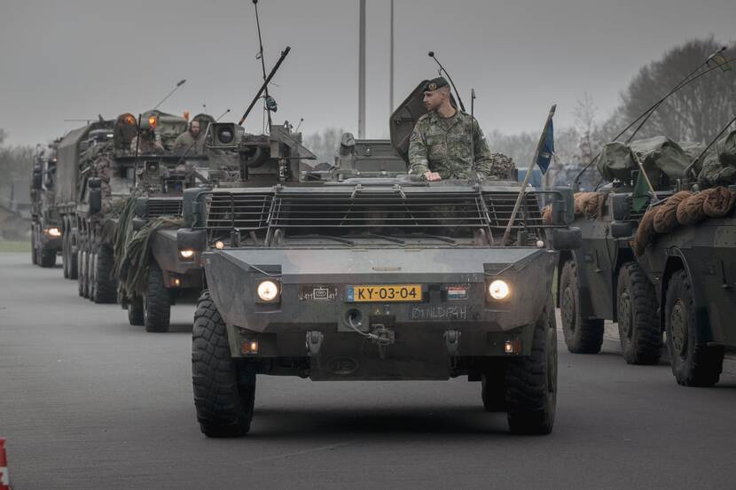 Verschillende militairen voertuigen verplaatsen zich in een colonne.