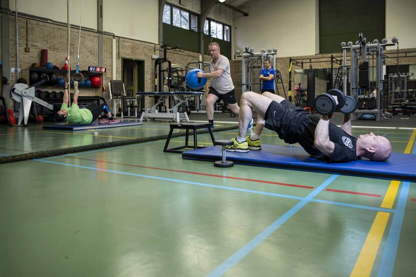 4 personen aan het sporten in een gymzaal.