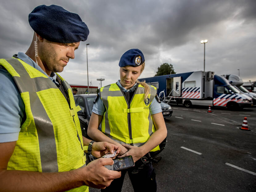 2 marechaussees checken een rijbewijs.