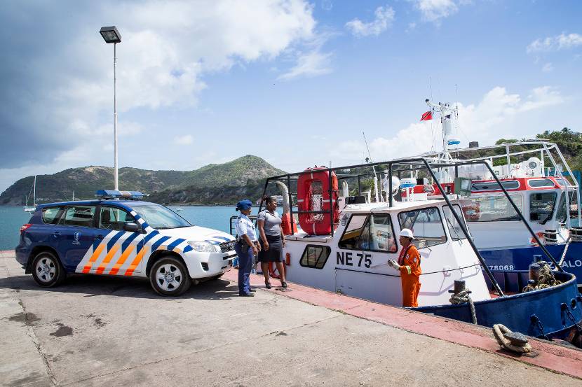 2 marechaussees in een haven in het Caribisch gebied.