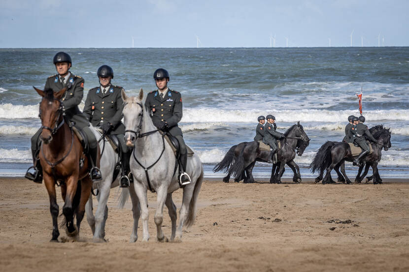 Militairen te paard tijdens het oefenen voor Prinsjesdag op het strand.