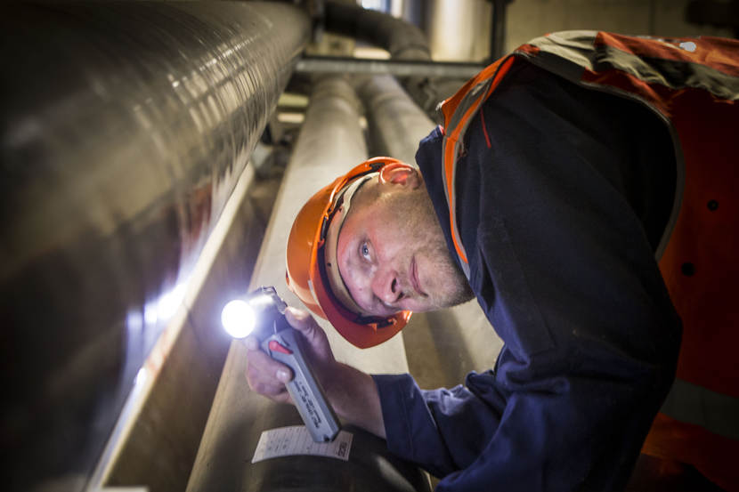 Medewerker van de DPO inspecteert een leiding.