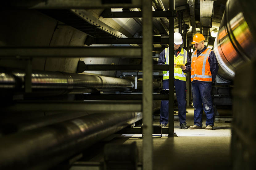 Onderhoudsmonteurs inspecteren leidingen in een van de leidingtunnels.