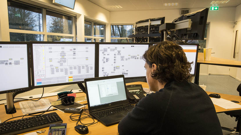 Medewerker centrale controlekamer houdt op computerschermen dat status van de pijpleidingen bij.