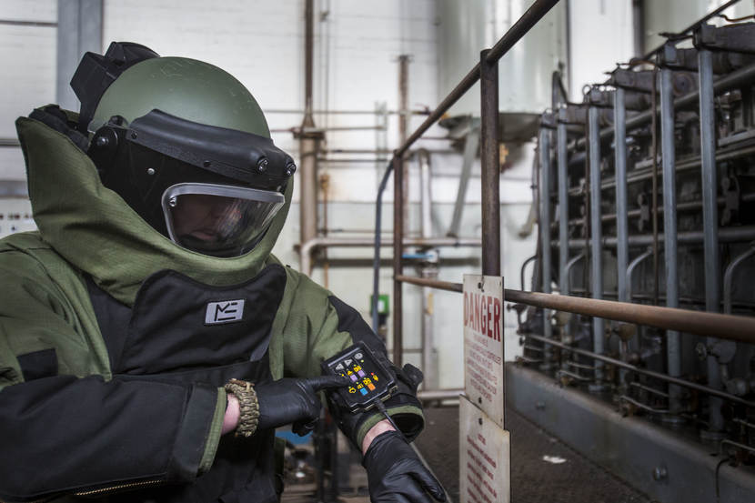 Een explosieven ruimer bedient het communicatiepaneltje op de mouw van het zware bommenpak tijdens oefening Lowlands Grenade (Duitsland, 2016).