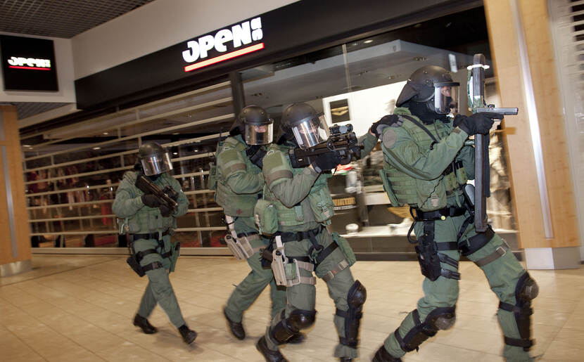 4 leden van de Unit Interventie Mariniers lopen in volledige uitrusting door een winkelcentrum.