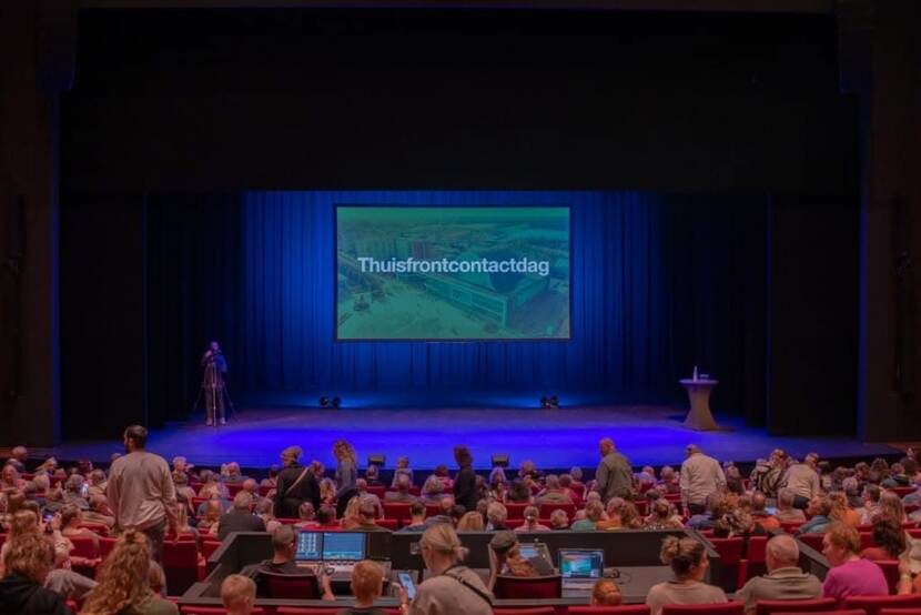 Een bioscoopzaal vol met mensen. Op het beeld de tekst: thuisfrontcontactdag.