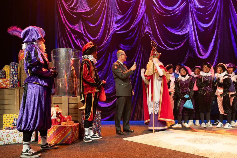 Sinterklaas en zijn Pieten spreken met een militair.