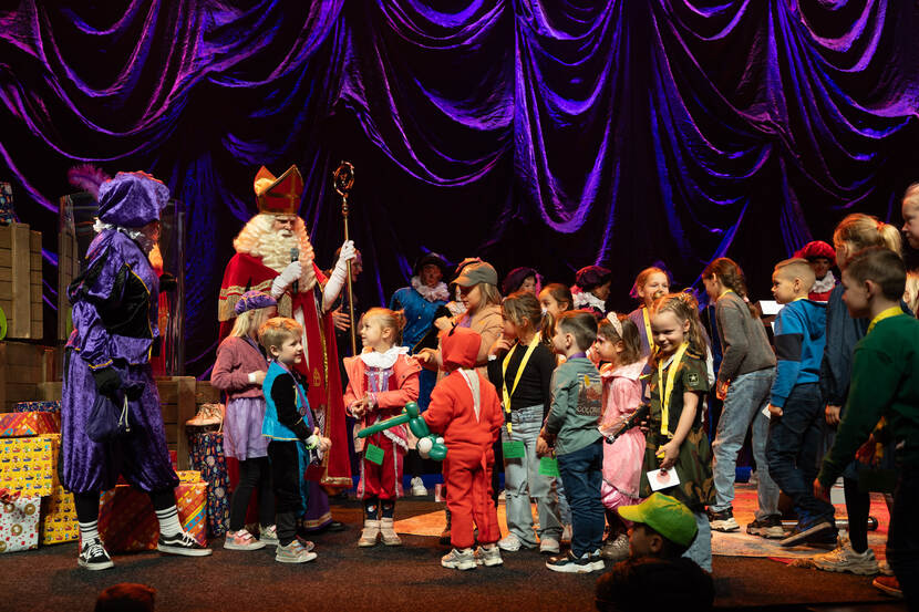 Kinderen worden toegesproken door Sinterklaas.