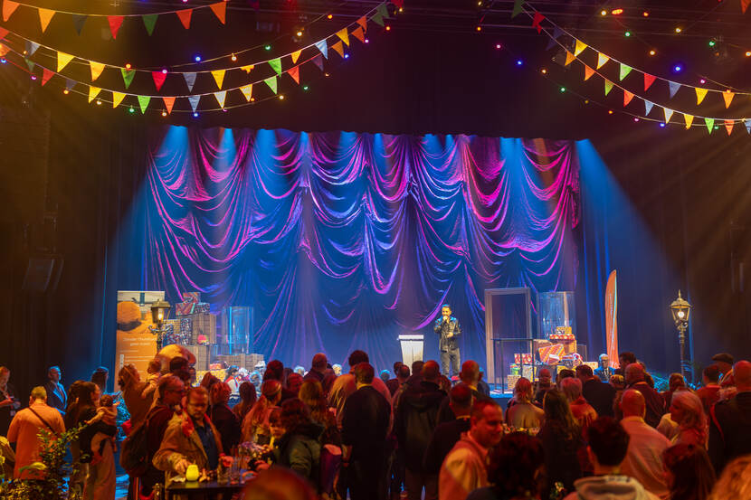 Een militair spreekt voor vele bezoekers vanaf het podium.